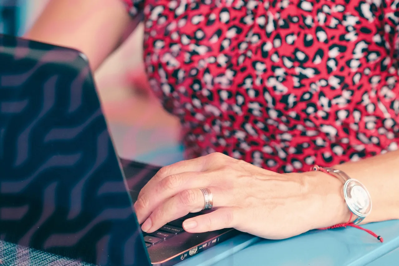 woman, hands, laptop, typing, work, office, business, freelance, remote work, technology, red dress, fashion, bracelet, watch, female, internet, keyboard, communication, writing, digital, lifestyle, creative, online, modern, closeup. Write a clear virtual assistant agency proposal for the approver who skipped the call