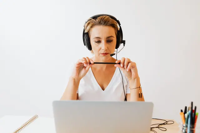 Adult woman in headphones using laptop for remote work in a home office setting. What should a virtual assistant agency errors and omissions policy cost?