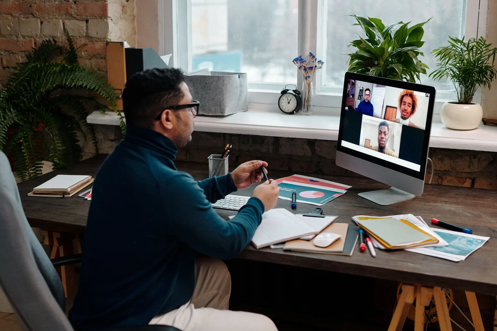 Man engaging in an online meeting from home office, showcasing remote work dynamics. Virtual assistant agency services: models and operating fit