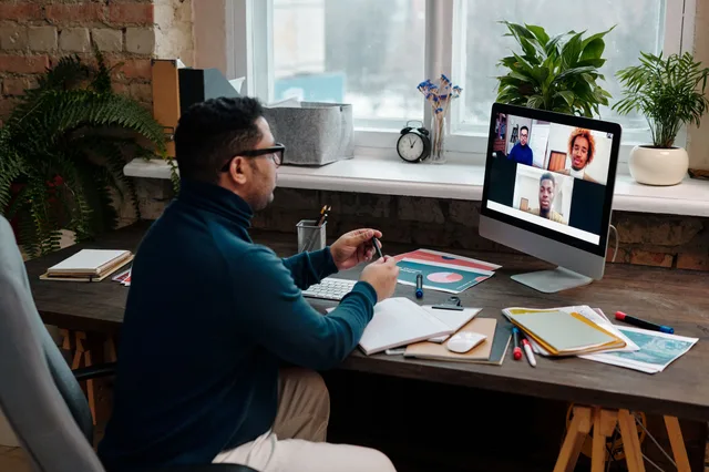 Man engaging in an online meeting from home office, showcasing remote work dynamics. Virtual assistant agency services: models and operating fit